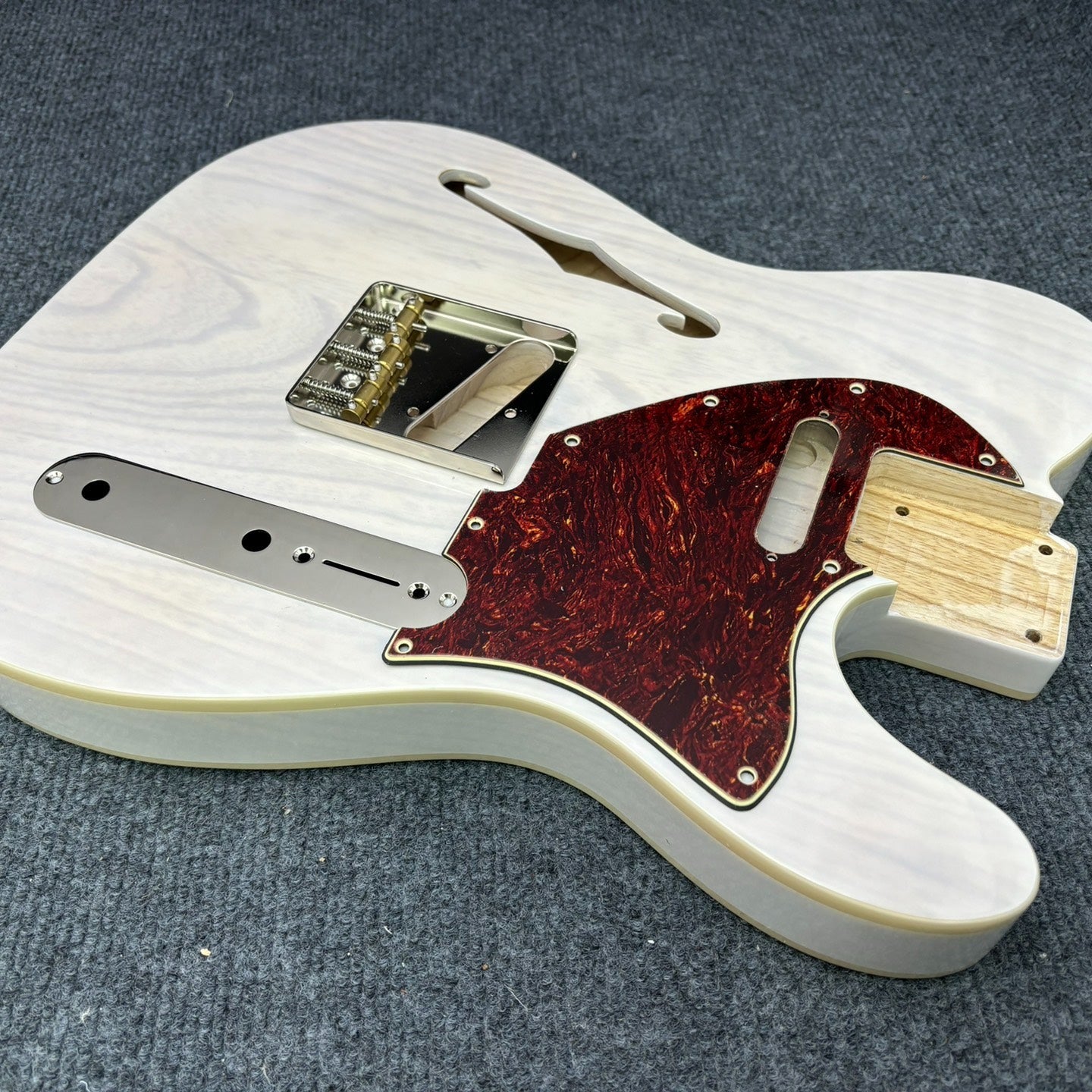 The semi-hollow body of TL electric guitar is 55.9mm wide and 17mm deep, with standard brass bridge and customized circuit.