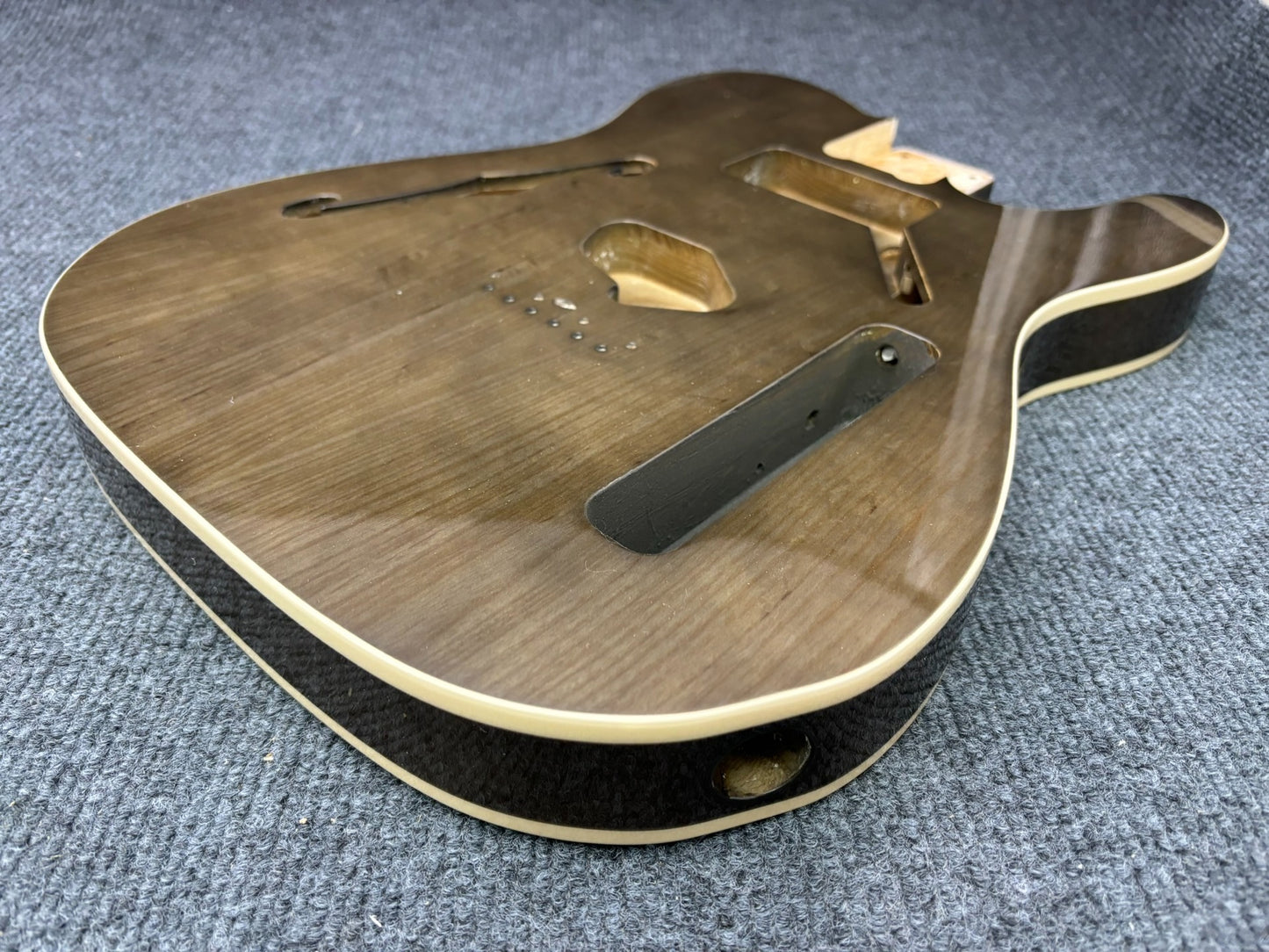 The semi-hollow body of TL electric guitar is 55.9mm wide and 17mm deep, with standard brass bridge and customized circuit.