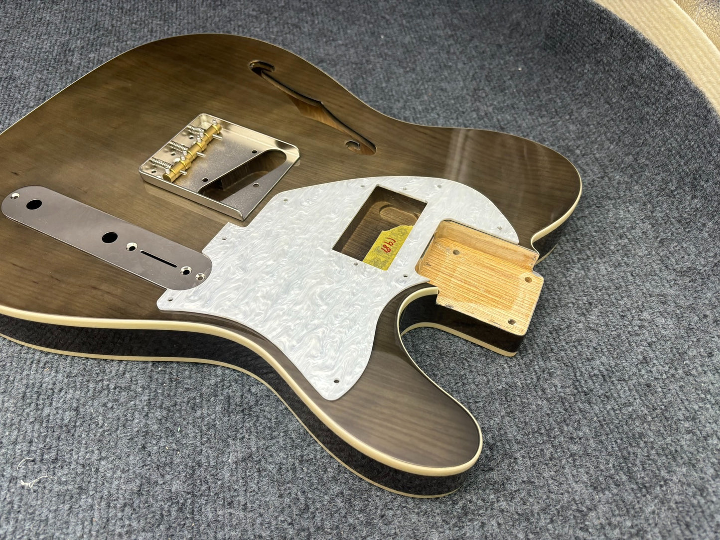 The semi-hollow body of TL electric guitar is 55.9mm wide and 17mm deep, with standard brass bridge and customized circuit.